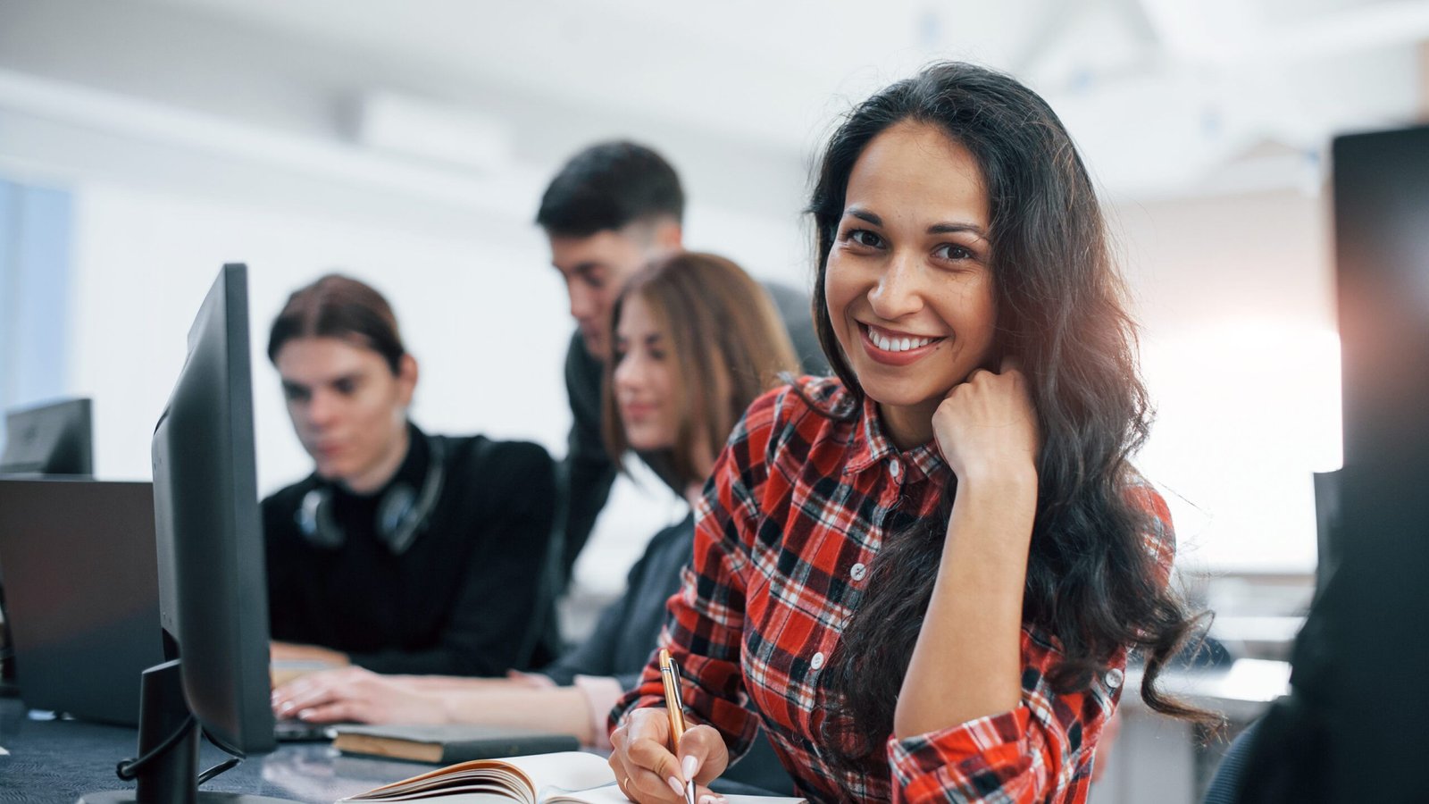 Cheerful brunette. Group of young people in casual clothes working in the modern office.